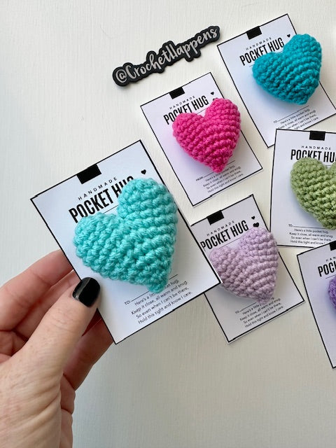 Stuffed crocheted hearts on gift card held in hand