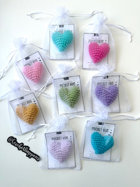 collection of hand crocheted pocket hug stuffed hearts on gift cards in packaging